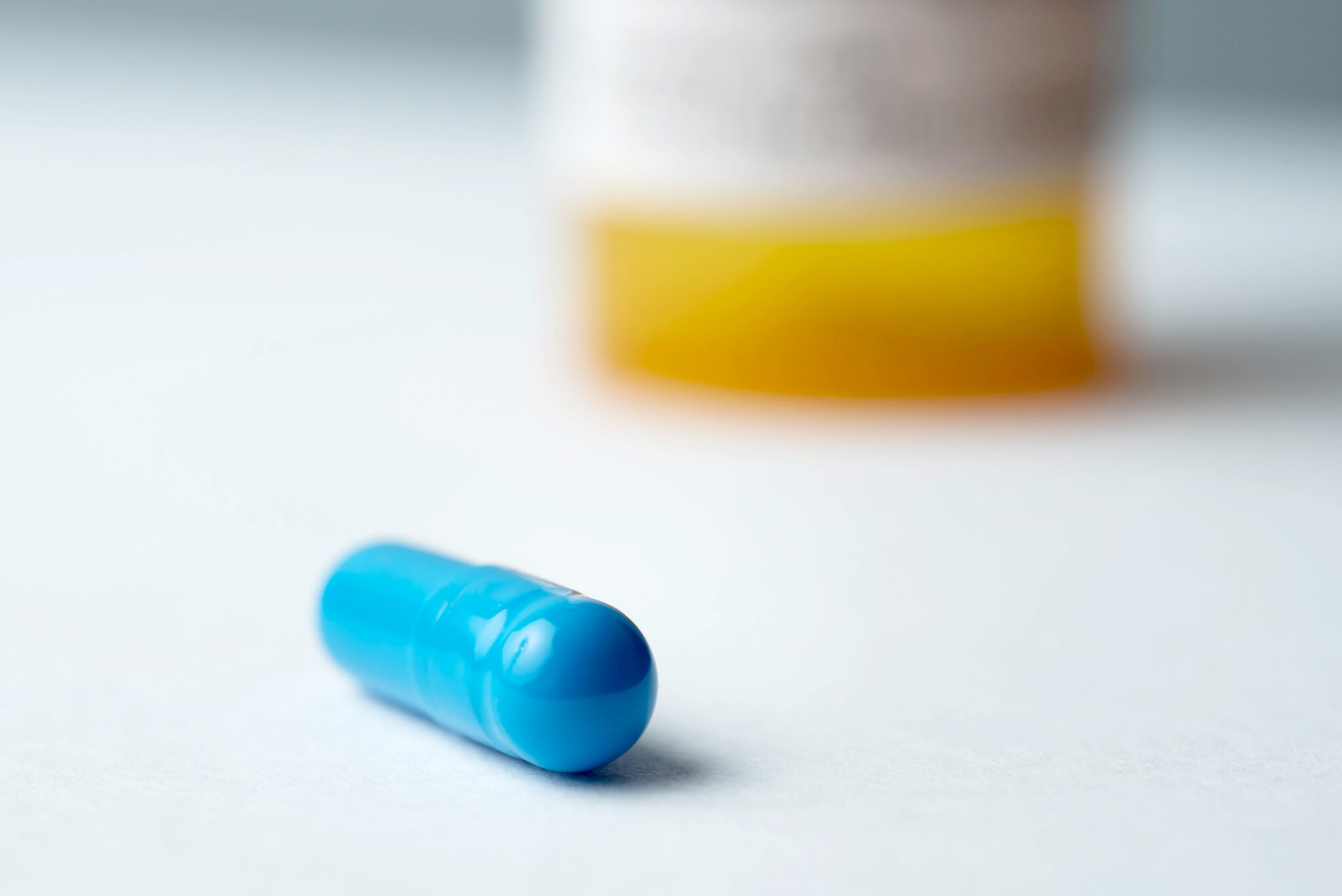 A psilocybin pill in front of pill bottle