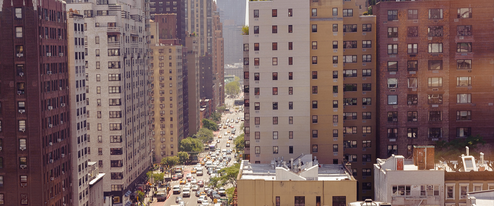 Tall buildings in New York City next to a busy street