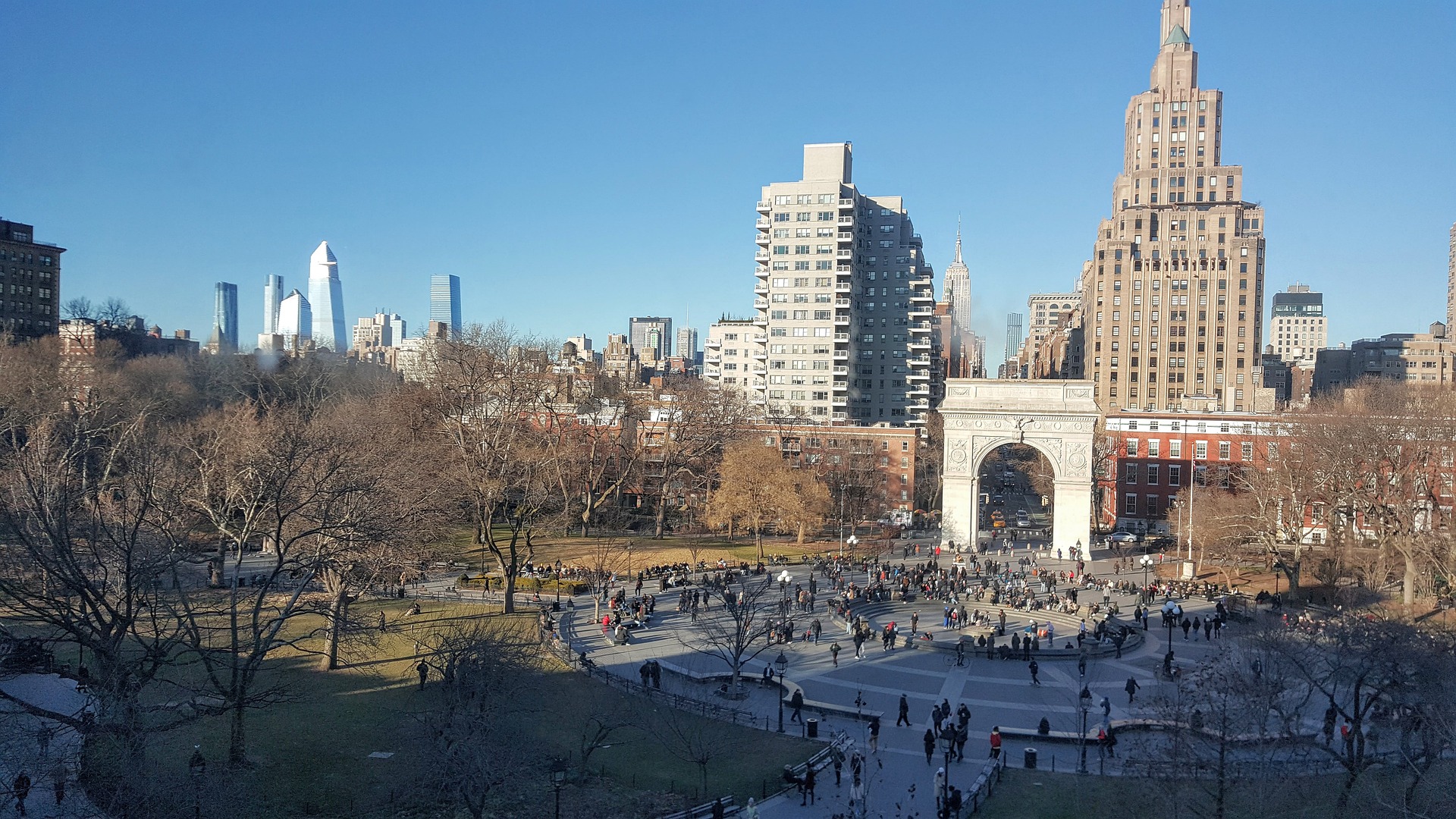 Washington Square Park in daytime, with sunlight shining directly on the Arch